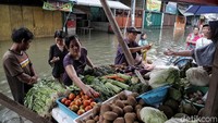 Sejumlah pedagang nampak kembali menggelar lapak dagangannya di kawasan Pasar Teluk Gong yang masih terendam banjir di Jakarta Utara, Jumat (3/1/2020).