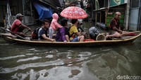 Sejumlah warga menggunakan jasa ojek perahu di kawasan Kelurahan Pejagalan, Jakarta Utara, Jumat (3/1).