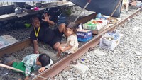 Warga mendirikan tenda menggunakan terpal sederhana.