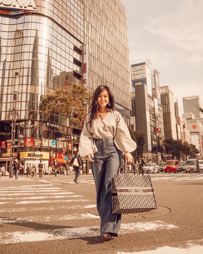 Wanita yang hobi travelling itu pun kerap memamerkan koleksi tas mewahnya. Dalam foto saat ia tengah berlibur di Tokyo ini, Titan menggunakan tas Dior custom dengan tertulis namanya.  Foto: Instagram @titantyra