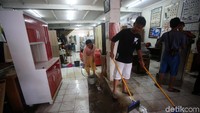Para pedagang membersihkan tokonya usai diterjang banjir di Jalan Ir Juanda, Bekasi, Jawa Barat, Jumat (3/1/2020).