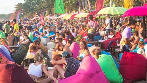 Bali, Indonesia - January 9 2014: Toursits enjoy a drink in a beach bar along Seminyak beach, just north of Kuta, in Bali.