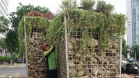 Petugas Dinas Kehutanan DKI Jakarta menghias sekitar instalasi batu gabion dengan menanami tanaman hias.