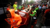 Petugas mengangkut sampah-sampah sisa banjir yang telah dikumpulkan untuk dibersihkan dari kawasan tersebut.