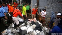 Warga bersama petugas gabungan yang terdiri dari prajurit TNI, polisi, Satpol PP hingga pegawai PNS DKI Jakarta ikut serta dalam kerja bakti membersihkan sampah sisa banjir di kawasan Jakarta Timur, Minggu (5/1/2020).
