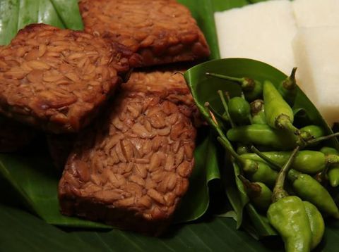 Tempe Bacem, the traditional Javanese dish of tempeh (soy bean cake) braised in soy sauce. A popular accompaniment for many other Javanese dish, such as with Jadah, the glutinous rice and coconut cake. The dish are placed on a woven bamboo tray lined with banana leaf. Jadah tempe are eaten with fresh green chili pepper.