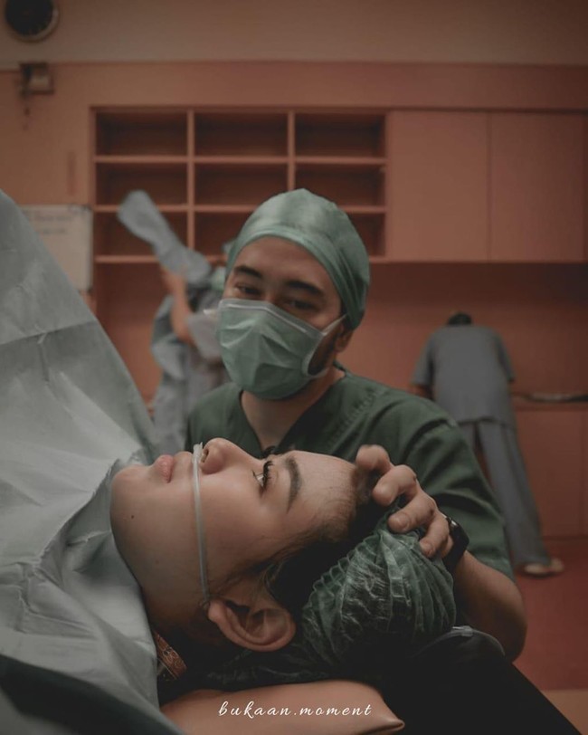 Syahnaz melahirkan anak kembarnya melalui proses caesar. Ia pun ditemani sang suami yang menanangkan dan mengalihkan perhatian. Proses operasi udah dimulai... suamikk yg slalu nenangin dgn cara alihin perhatian aku pas perut mulai dibelekkk, pas ini dia alihinnya ngomong “bulu mata kamu bagus bgt deh” hmmm krik krik.. kirain mau ngomong km cantik deh, tulisnya. Foto: Instagram @syahnazs