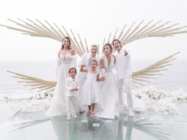 Serba putih menjadi pilihan tema untuk busana pengantin dan keluarga. Pada pernikahannya Kim Kurniawan mengenakan kemeja, blazer, vest hingga dasi kupu-kupu putih. Sedangkan mempelai wanitanya, Elisa mengenakan gaun putih cantik rancangan Shella Natasia. Foto: dok. Instagram @bridetsory