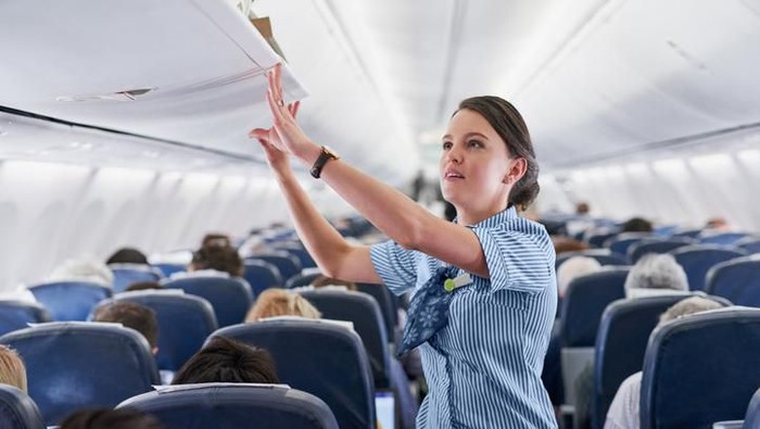 High quality stock photo of a young boy playing and using a tablet computer on an airport plane.