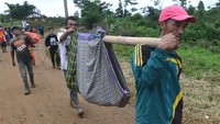 Warga korban longsor di Desa Sukajaya, Bogor, Jawa Barat, mengevakuasi salah satu kerabatnya yang sakit pada Minggu (5/1/2020).