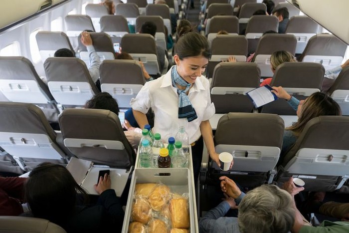 High quality stock photo of a young boy playing and using a tablet computer on an airport plane.