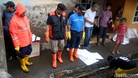 Anies mengenakan jaket seragam BPBD DKI Jakarta lengkap dengan sepatu boots dan sarung tangan karet berwarna oranye.