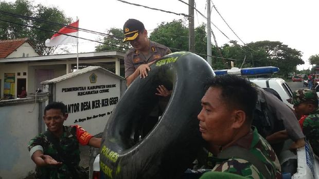 Polisi dan TNI membagikan ban dalam kepada warga