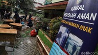 Para guru membersihkan beragam perabotan yang kotor di halaman sekolah.