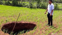 Kepala Dusun Karangawen, Yuono menunjukkan lubang menyerupai sinkhole di sebuah lahan pertanian Dusun Karangawen, Desa Karangawen, Kecamatan Girisubo, Kabupaten Gunungkidul, Senin (6/1/2020).