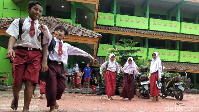 Siswa SDN 01 Kapuk Muara, Jakut, memulai hari pertama masuk sekolah dengan bersih-bersih kelas. Pasalnya sekolah itu sebelumnya terendam banjir.