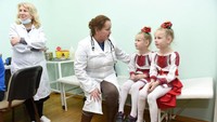 Dua anak kembar saat menunggu vaksinasi gondok, campak dan rubella (MMR) di kawasan Lviv, Ukranina, pada bulan Februari lalu saat kampanye vaksin. Istimewa/UNICEF/Dyachyshyn.