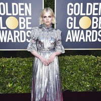 Penampilan Lucy Boynton terkesan kaku dalam balutan gaun serba metalik ini. (Foto: Jordan Strauss/Invision/AP)