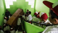 Guru dan siswa bergotong-royong membersihkan ruang kelas di hari pertama masuk sekolah.