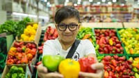 Seorang anak laki-laki memamerkan beberapa paprika di depan kamera di sebuah supermarket di Almaty, Kazakhstan. Istimewa/UNICEF/Karimova.