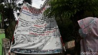 Seorang warga melintas di samping sebuah spanduk yang berisi penolakan trotoar digunakan PKL untuk berdagang dan parkir liar di kawasan Jalan Kramat Raya, Jakarta Pusat.