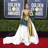 Gaya Jennnifer Lopez ini disebut netizen mirip kado Natal lantaran pita besar di gaun Valentino yang dipakainya. Anda setuju? (Foto: Jordan Strauss/Invision/AP)