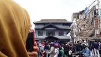 Warga menyaksikan proses evakuasi ruko yang roboh di Slipi.