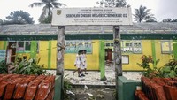 Sejumlah siswa melintas di depan sekolah yang rusak dan ambruk di SDN Cirimekar 02, Cibinong, Kabupaten Bogor, Jawa Barat, Senin (6/1/2020).
