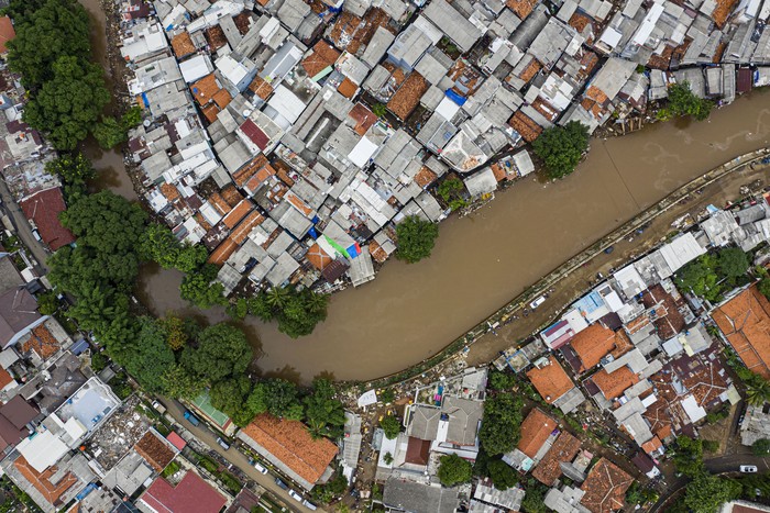 Foto udara suasana wilayah bantaran sungai Ciliwung yang belum dinormalisasi (atas) dan yang sudah dinormalisasi (bawah kanan) di kawasan Bukit Duri, Jakarta, Minggu (5/1/2020). Rencana pembangunan tanggul normalisasi atau naturalisasi yang menjadi program Gubernur Anies Baswedan hingga saat ini belum mencapai target yaitu hanya 16,19 km dari total 33,69 km dikarenakan terkendala pembebasan lahan. ANTARA FOTO/Muhammad Adimaja/aww.
