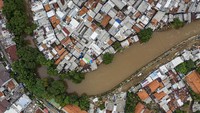 Tampak (kiri gambar) sungai Ciliwung semakin menyempit dan ditumbuhi pepohonan yang rindang. Sementara di (kanan) gambar, sudah tampak rapi dan cukup luas. Rencana pembangunan tanggul normalisasi atau naturalisasi yang menjadi program Gubernur Anies Baswedan hingga saat ini belum mencapai target yaitu hanya 16,19 km dari total 33,69 km dikarenakan terkendala pembebasan lahan.