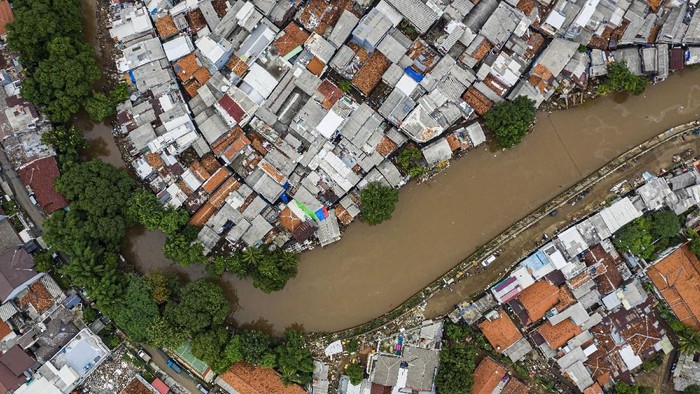 Foto udara suasana wilayah bantaran sungai Ciliwung yang belum dinormalisasi (atas) dan yang sudah dinormalisasi (bawah kanan) di kawasan Bukit Duri, Jakarta, Minggu (5/1/2020). Rencana pembangunan tanggul normalisasi atau naturalisasi yang menjadi program Gubernur Anies Baswedan hingga saat ini belum mencapai target yaitu hanya 16,19 km dari total 33,69 km dikarenakan terkendala pembebasan lahan. ANTARA FOTO/Muhammad Adimaja/aww.