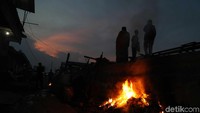 Beberapa warga tampak membakar sampah di samping tanggul Jakarta. Karena ancaman air laut di Jakarta bukanlah sebuah mitos. Sudah siapkah kita?
