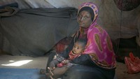 Seorang balita dan ibunya terlihat duduk di sebuah tenda darurat bagi orang-orang terlantar di Yaman. Istimewa/UNICEF/Baholis.