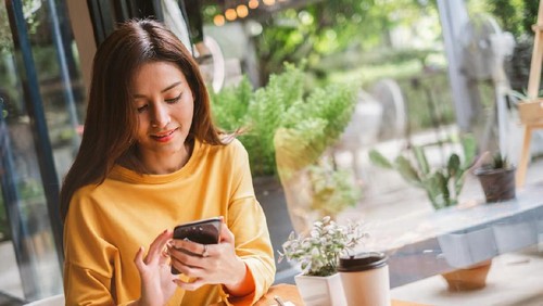 Young Asian beautiful woman using smart phone for business, online shopping, transfer money, financial, internet banking. in coffee shop cafe over blurred background.