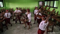 Para siswa bahu membahu membersihkan ruang kelas dan mengangkut bangku dan juga meja belajar dari lantai atas ke ruang kelas di lantai dasar yang sebelumnya terendam banjir.