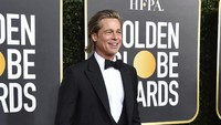 Brad Pitt terlihat necis dengan setelan jas hitam. Frazer Harrison/Getty Images