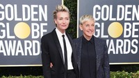 Ellen DeGeneres tampil bersama istrinya, Portia De Rossi, yang bergaya androgini dengan setelan jas hitam. Jon Kopaloff/Getty Images