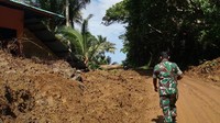 Anggota TNI berjalan di lokasi permukiman yang tertutup material tanah akibat banjir bandang di Desa Lebo, Manganitu, Kabupaten Kepulauan Sangihe, Sulawesi Utara, Senin (6/1/2020). ANTARA FOTO/Ipang Posoh.