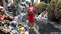 Seorang anak memperlihatkan sebuah buku yang terendam banjir di Madrasah Ibtidaiyah Nurul Yaqin di Jakarta Barat, Selasa (7/1/2020).