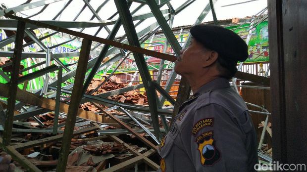 Seorang polisi melihat kondisi atap SDN Palebon 01 Semarang yang roboh