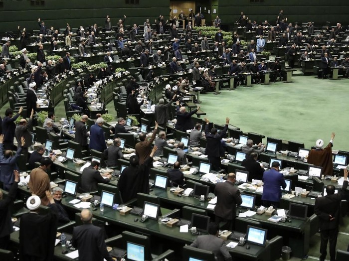 Some Iranian lawmakers encourage their colleagues to vote for a bill in an open session of parliament, in Tehran, Iran, Tuesday, Jan. 7, 2020. Irans parliament has passed an urgent bill declaring the U.S. militarys command at the Pentagon in Washington and those acting on its behalf 
