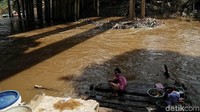 Seorang warga memanfaatkan aliran sungai untuk mandi dan beraktivitas sehari-hari. Padahal, aliran sungai itu tampak kotor dan keruh tak layak untuk dipergunakan.