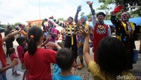 Para badut mengajak anak-anak menari dan bernyanyi bersama untuk menghilangkan trauma pasca banjir.