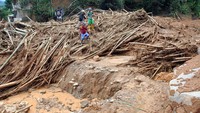 Sejumlah warga melewati tanah longsor saat mengungsi di Kampung Banar, Desa Harkat Jaya, Kecamatan Sukajaya, Kabupaten Bogor, Jawa Barat, Selasa (7/1/2020). 
