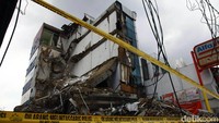 Garis polisi masih terpasang di lokasi gedung yang roboh di Slipi.