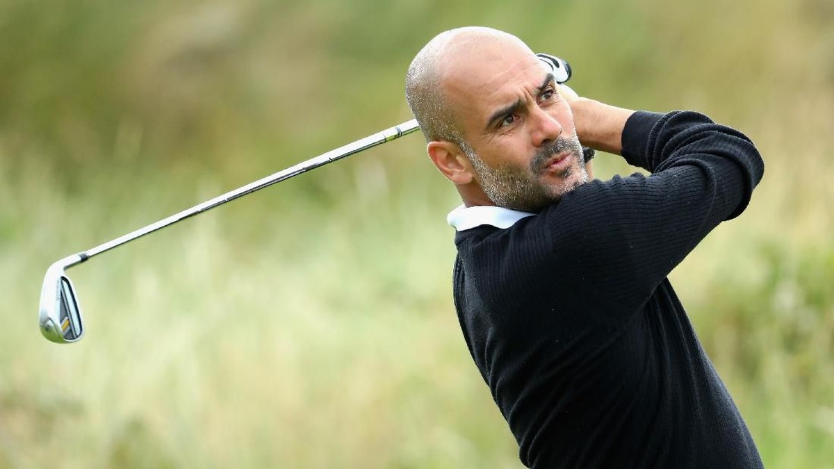 Pep Guardiola mengayunkan stik golf. (Foto: Photo by Warren Little/Getty Images)