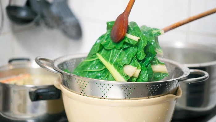 Preparing healthy lunch in the kitchen, blanching chard using kitchen utensils