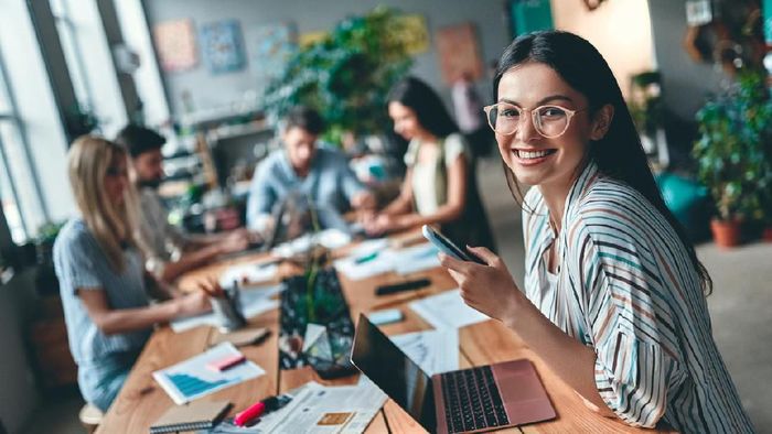 zodiak Group of young business people are working together in modern office. Creative people with laptop, tablet, smart phone, notebook. Successful hipster team in coworking. Freelancers.