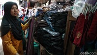 Seorang warga tengah memilih seragam dan berbagai perlengkapan sekolah lainnya di Pasar Jatinegara.