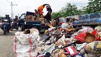 Petugas sedang mengangkut sampah-sampah sisa banjir di pinggir Jalan Inspeksi Kali Mookervaart, Cengkareng, Jakarta.